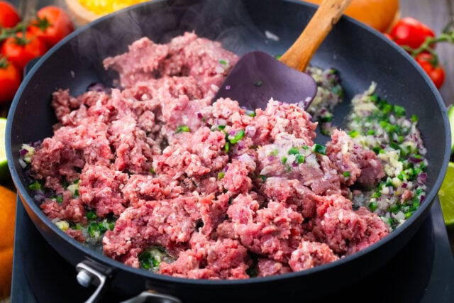 Cooking the ground meat in a pan.