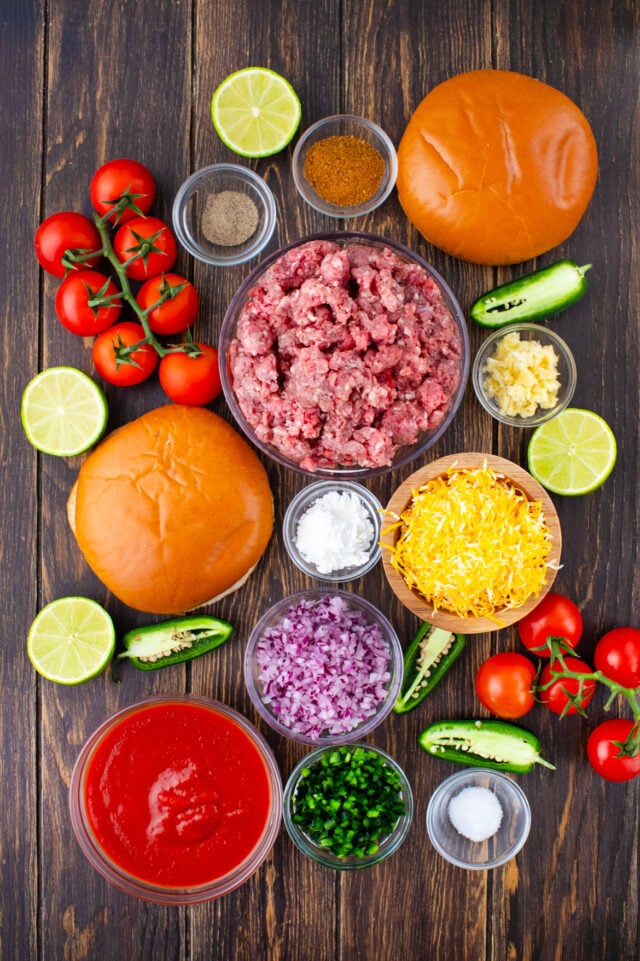 Overhead shot of taco sloppy Joes ingredients in bowls on a wooden table.