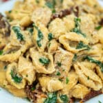 Tuscan Chicken Pasta is a quick and easy one-pan dish made with crispy chicken, sun-dried tomatoes, shell pasta, and soaked in a creamy white sauce. #pasta #tuscanchicken #chickenrecipes #30minutemeals #onepotmeals