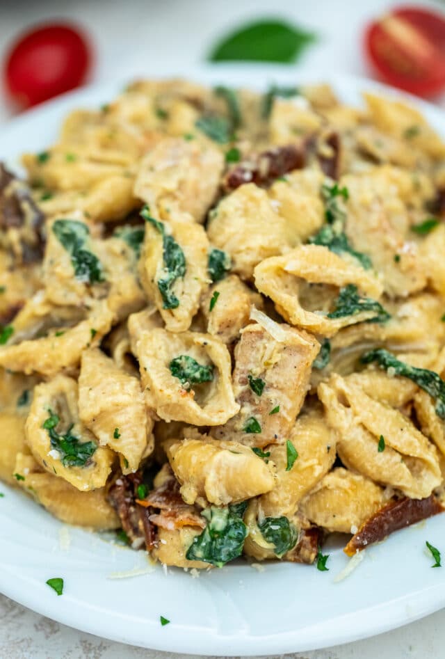 Tuscan Chicken Pasta is a quick and easy one-pan dish made with crispy chicken, sun-dried tomatoes, shell pasta, and soaked in a creamy white sauce. #pasta #tuscanchicken #chickenrecipes #30minutemeals #onepotmeals