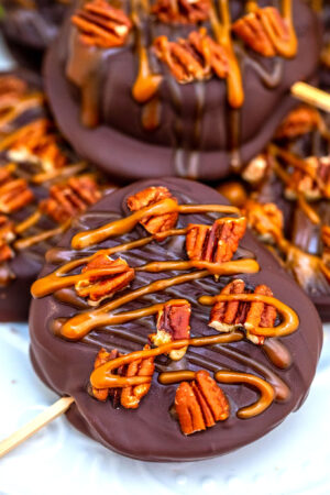 Chocolate Turtle Apples are made with sliced fresh apples, dipped in melted chocolate, drizzled with caramel sauce and topped with pecans. #fallrecipes #apples #caramel #30minutesmeals #halloween