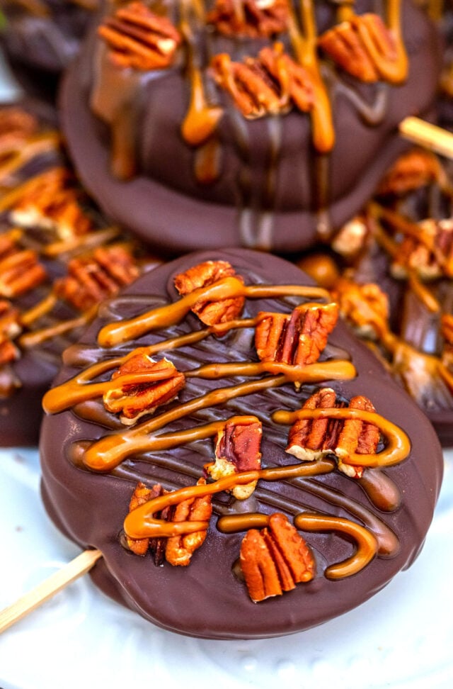 Chocolate Turtle Apples are made with sliced fresh apples, dipped in melted chocolate, drizzled with caramel sauce and topped with pecans. #fallrecipes #apples #caramel #30minutesmeals #halloween