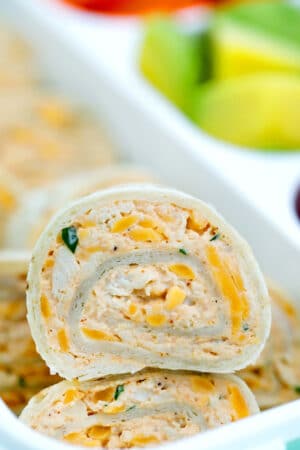 These Taco Tortilla Roll Ups are made with shredded chicken, cream cheese, taco seasoning, and cheddar cheese. #rollups #pinwheels #taco #partyfood #30minutemeals