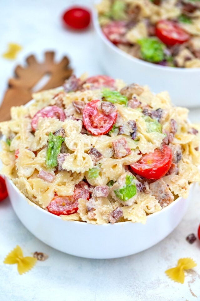 Chicken Caesar Pasta Salad is a refreshing dish made with chicken, bow tie pasta, Parmesan cheese, grape tomatoes, and bacon, all tossed in a creamy Caesar dressing. #chickencaesar #pastasalad #pastarecipes #potluckrecipes #30minutemeals