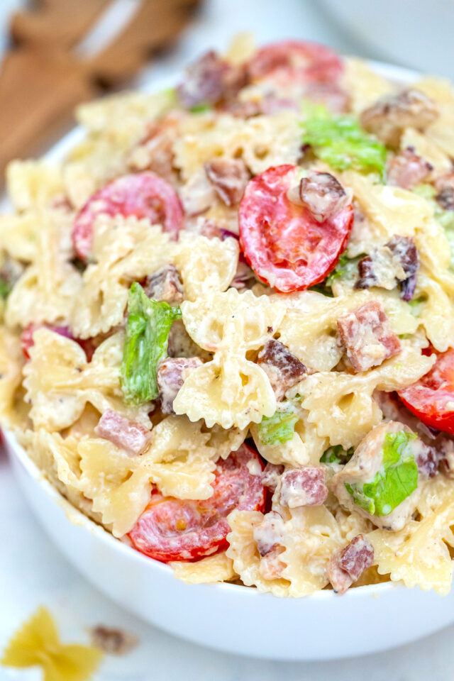 Chicken Caesar Pasta Salad is a refreshing dish made with chicken, bow tie pasta, Parmesan cheese, grape tomatoes, and bacon, all tossed in a creamy Caesar dressing. #chickencaesar #pastasalad #pastarecipes #potluckrecipes #30minutemeals