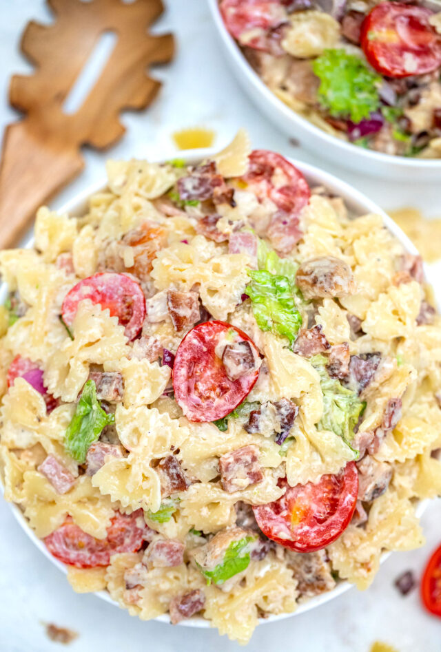 Chicken Caesar Pasta Salad is a refreshing dish made with chicken, bow tie pasta, Parmesan cheese, grape tomatoes, and bacon, all tossed in a creamy Caesar dressing. #chickencaesar #pastasalad #pastarecipes #potluckrecipes #30minutemeals