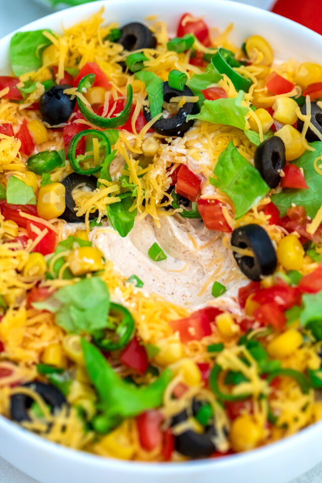 Taco Dip is the perfect snack for game day or party appetizer that is ready in just 5 minutes. #tacodip #appetizers #partyfood #30minutemeals #mexicanrecipes