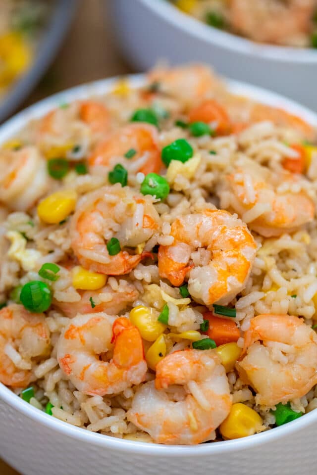 Shrimp Fried Rice recipe is made with fresh shrimp, rice, green onions, peas, carrots, and sesame oil. It is a classic dinner dish that is ready in about 30 minutes! #friedrice #shrimprecipes #30minutemeals #shrimpfriedrice #chineserecipes