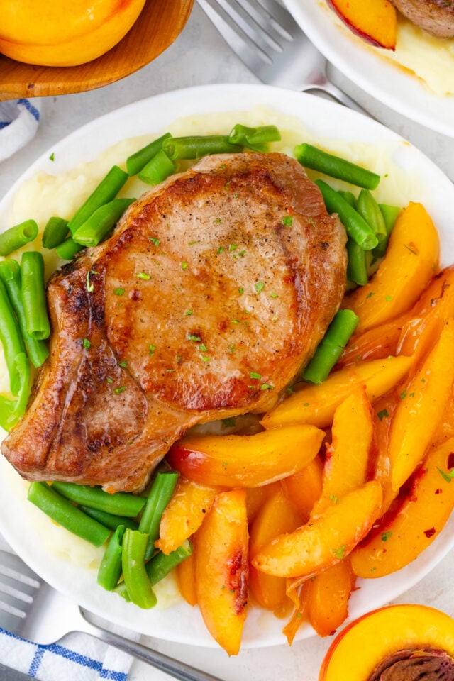 Bone in peach pork chops with green beans and mashed potatoes.