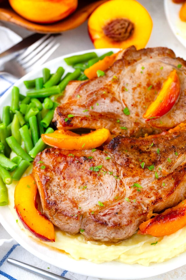 A plate of peach pork chops with greens.