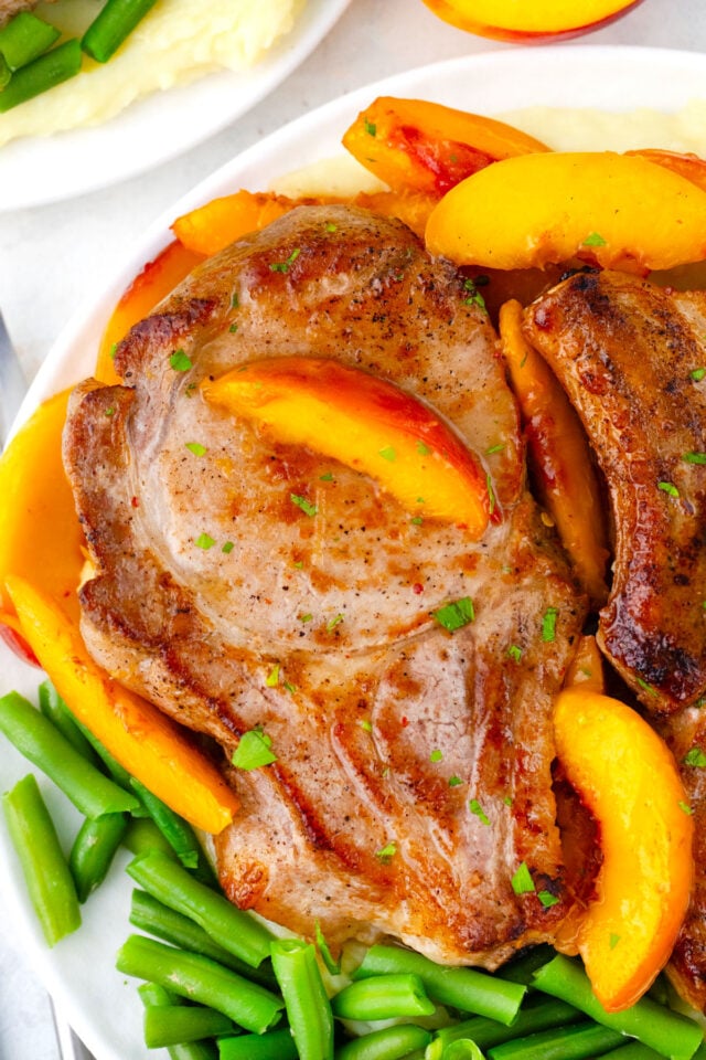 Juicy pork chops with green beans and peaches.