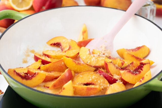 Saut&eacute;ing peaches in a cast iron pan.