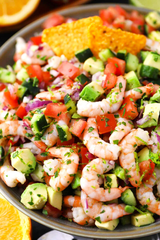 A bowl of homemade shrimp ceviche with cucumbers and avocado.
