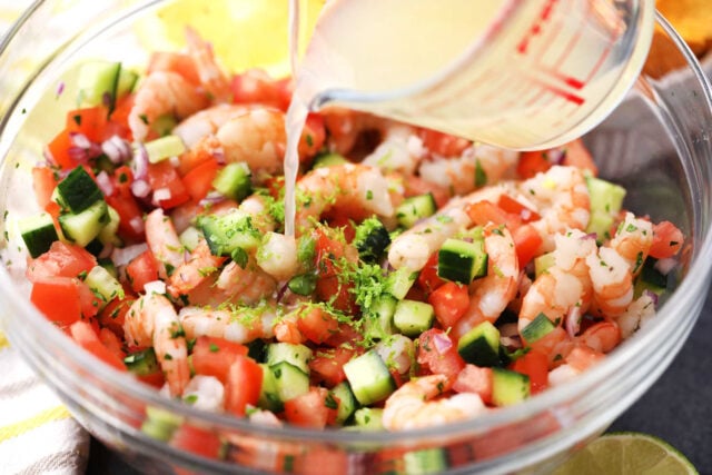 Adding lemon juice to homemade shrimp ceviche.