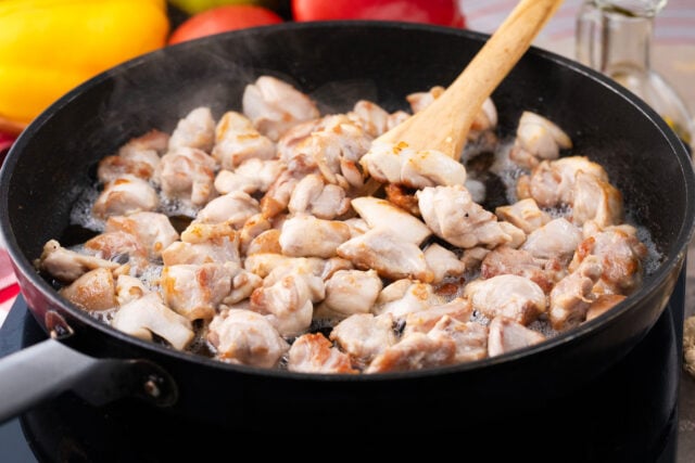 Cooking chicken pieces in a skillet.