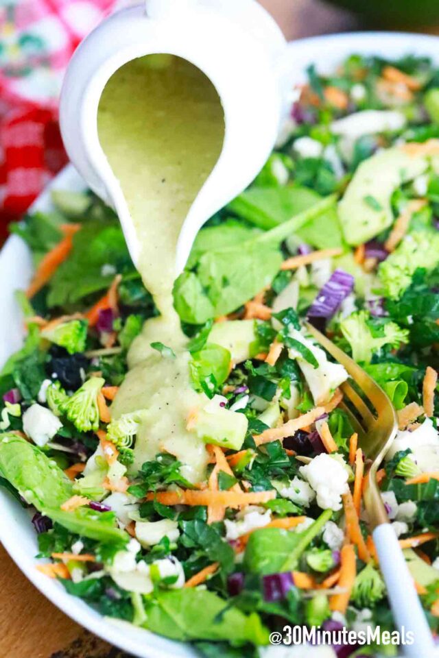 pouring avocado dressing on salad