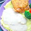 gravy on top of mashed potatoes with chicken and veggies