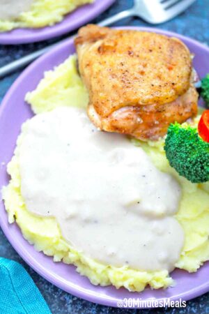 gravy on top of mashed potatoes with chicken and veggies