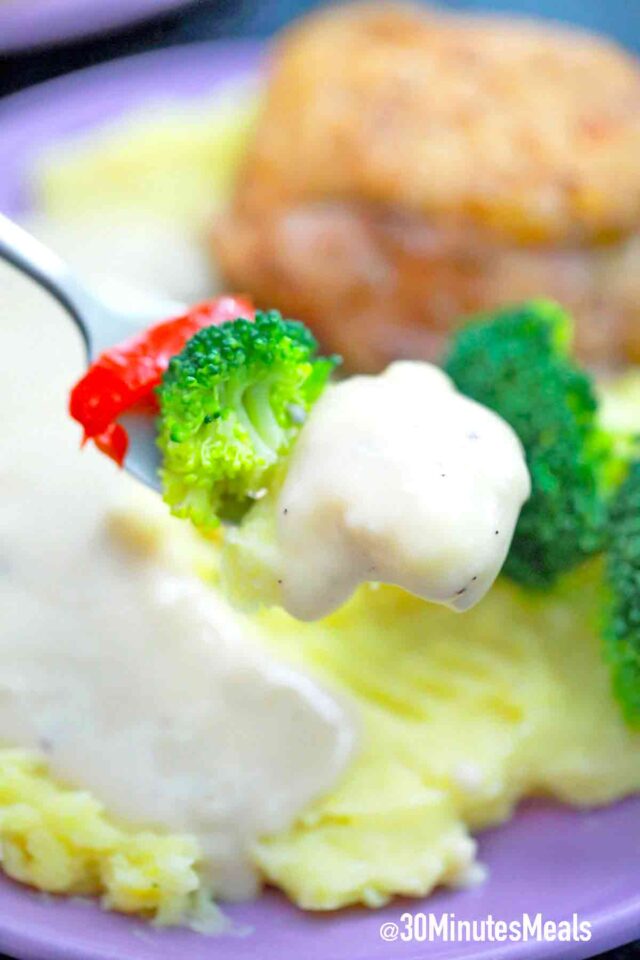 a forkful of veggies with gravy
