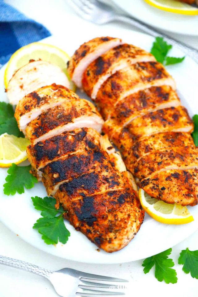 two blackened chicken breasts with lemon