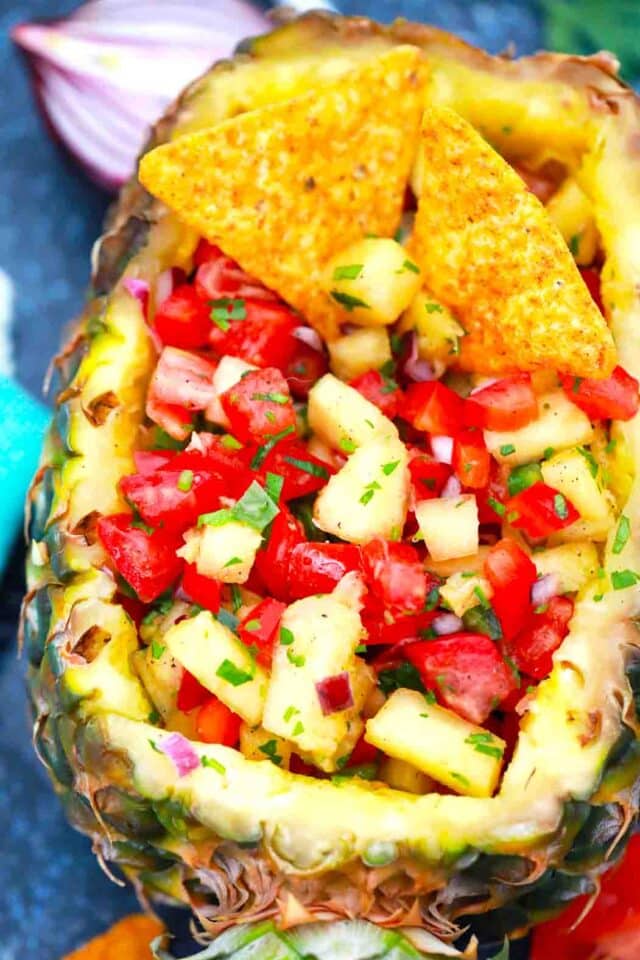 a pineapple with pineapple tomato salsa and corn chips