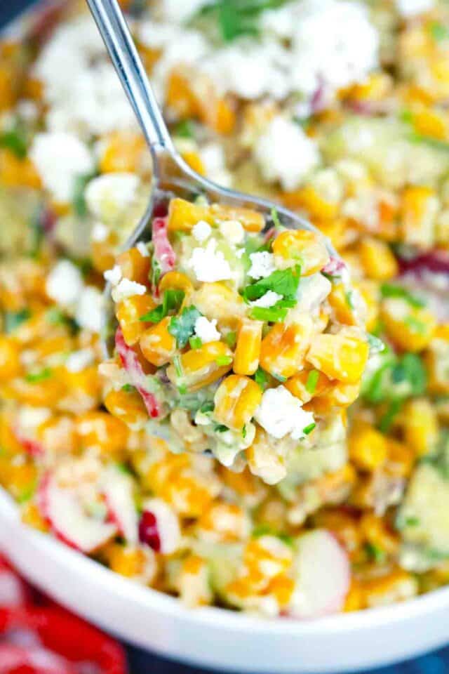 close macro shot of a spoonful of creamy avocado corn salad