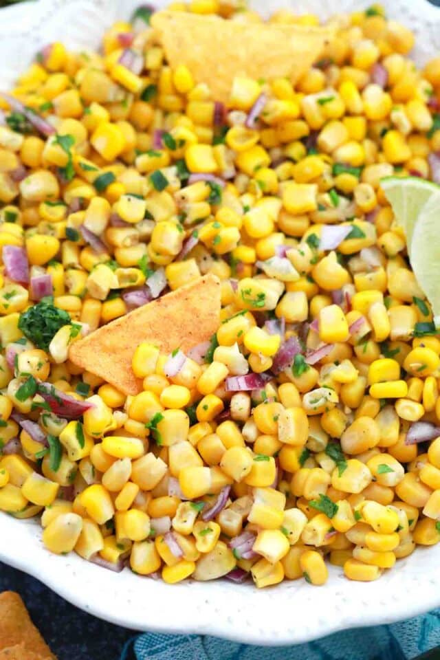 overhead shot of a plate of corn salsa with corn chips