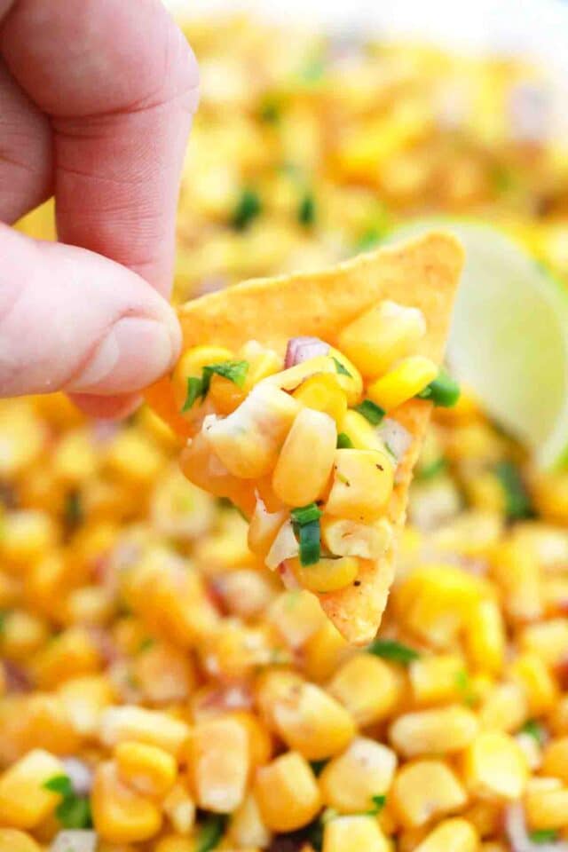 scooping corn salsa on chips