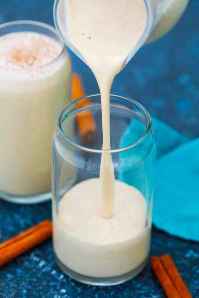 pouring puerto rican coquito in a glass