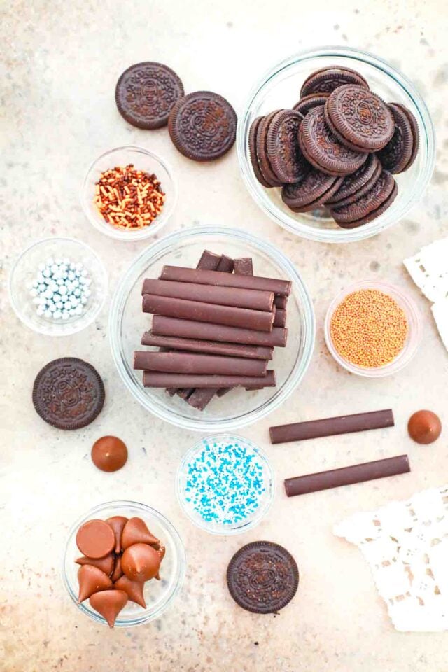 overhead shot of Oreos chocolate Hershey kisses and sprinkles in bowls