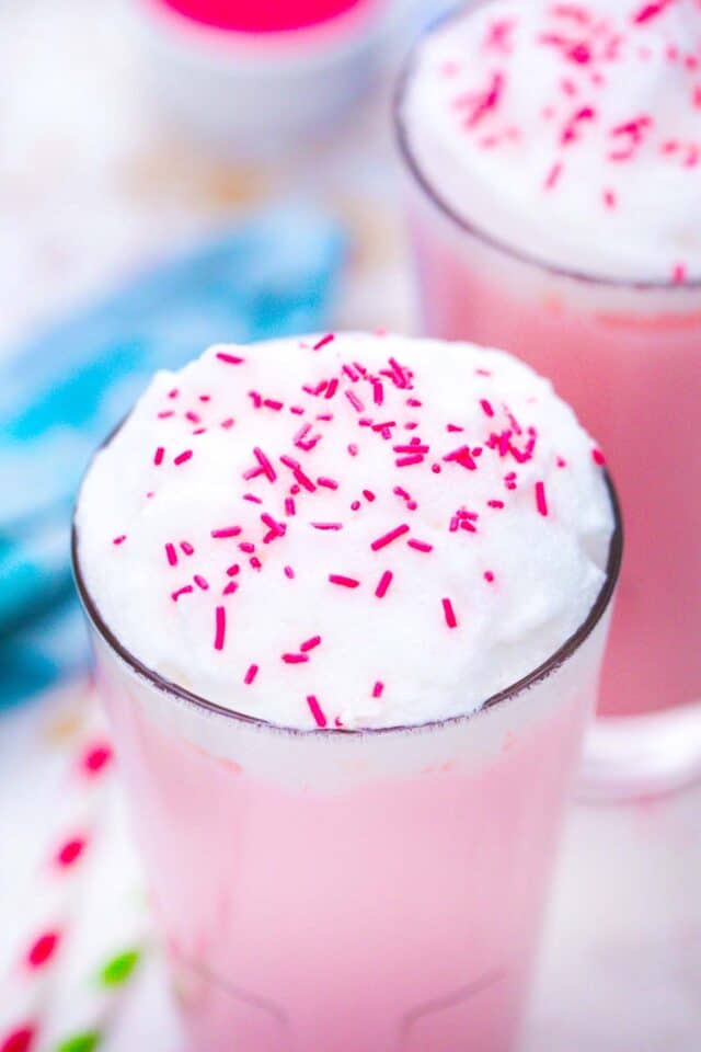 macro shot of the top of pink angel milk with whipped cream and sprinkles