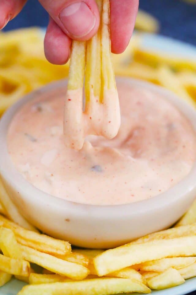 dipping three fries in creamy in n out sauce