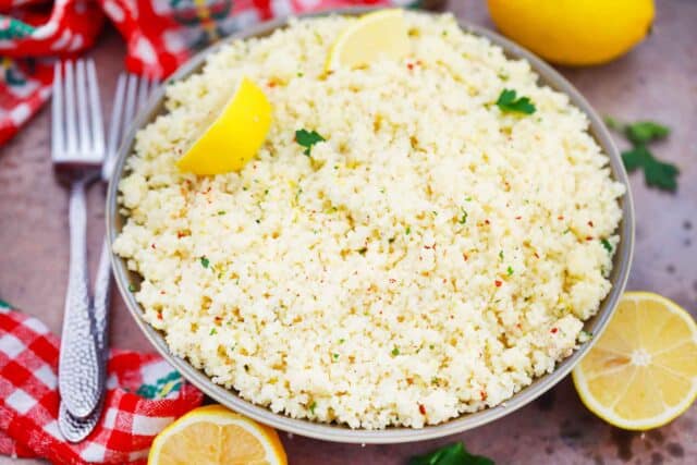 homemade lemon couscous in a bowl topped with a lemon wedge