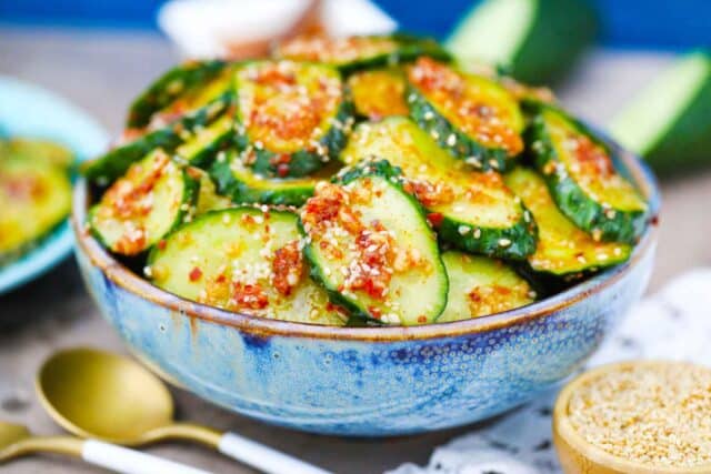 a blue bowl of spicy cucumber salad