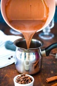 pouring mocha latte in a small coffee pot