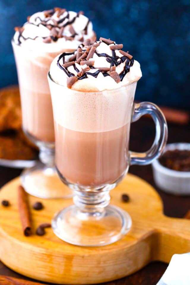 mocha latte on a serving board topped with whipped cream and chocolate sauce