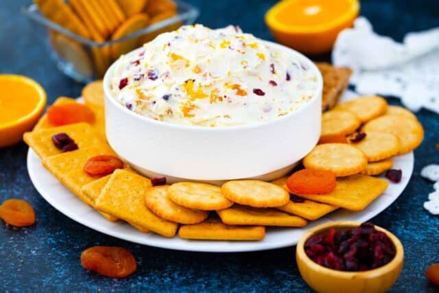 a bowl of cranberry cream cheese served with crackers