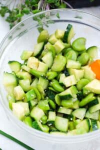 a bowl with chopped cucumbers avocado and edamame
