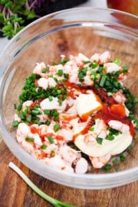 a bowl with shrimp mayo green onions and sriracha