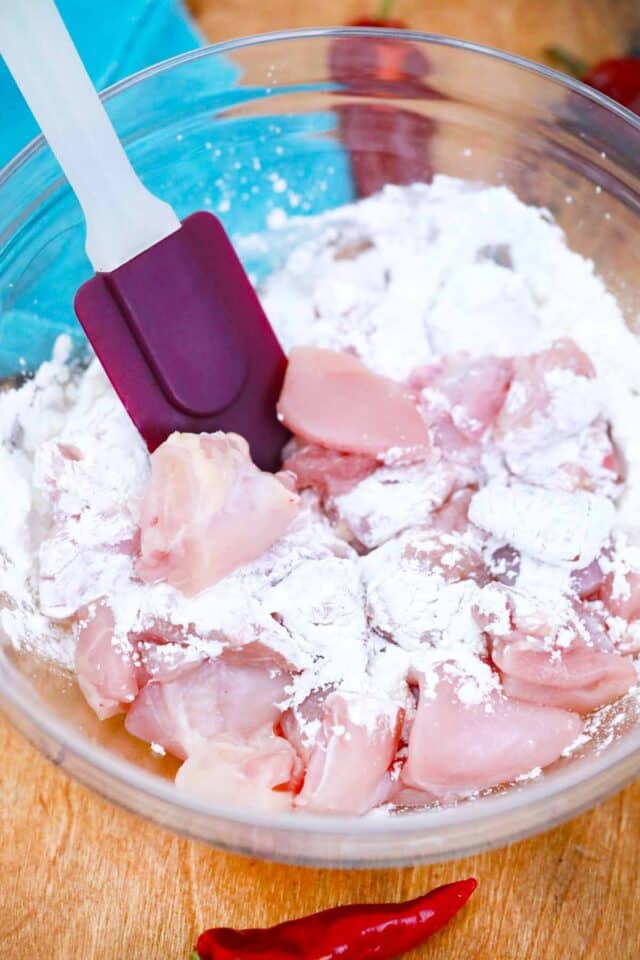 tossing chicken pieces in cornstarch in a bowl