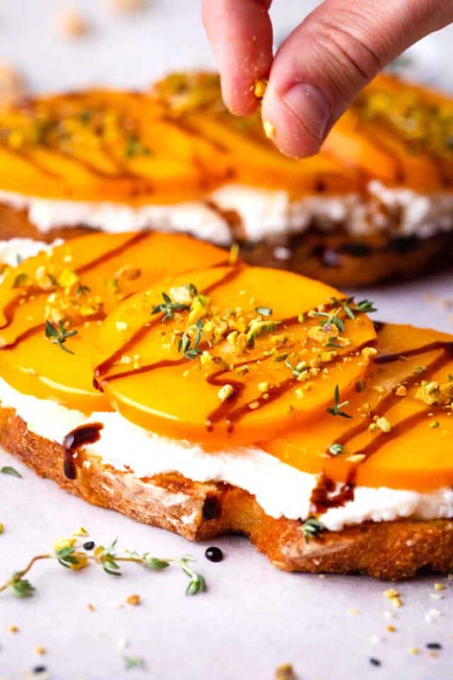 persimmon toast topped with chopped pistachios