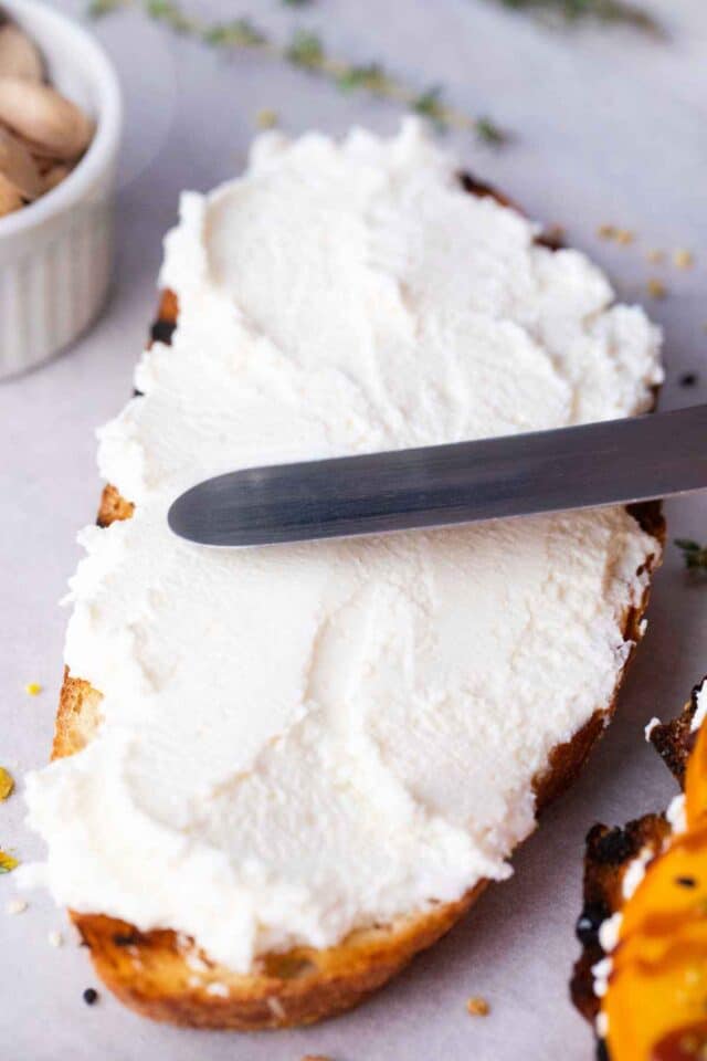 spreading ricotta on a slice of sourdough bread