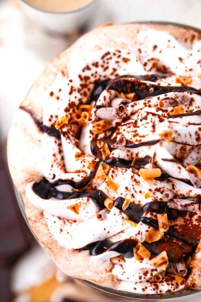 homemade baileys hot chocolate with whipped cream, chocolate sauce, and chocolate shavings