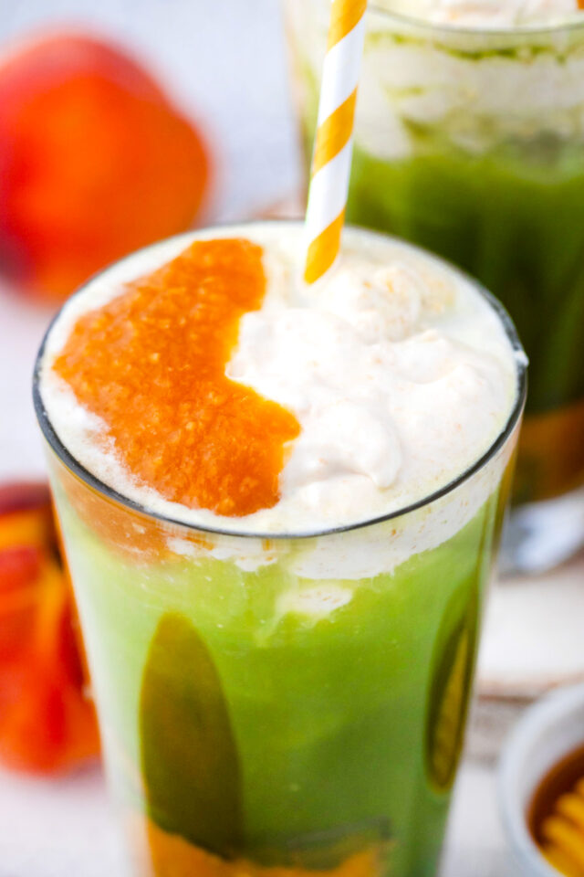 Creamy iced peach matcha freddo with peach puree.