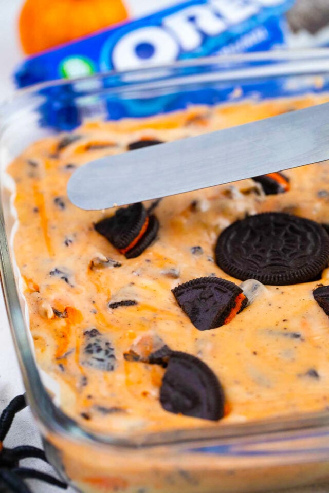 Adding Halloween Oreos on top of orange fudge.