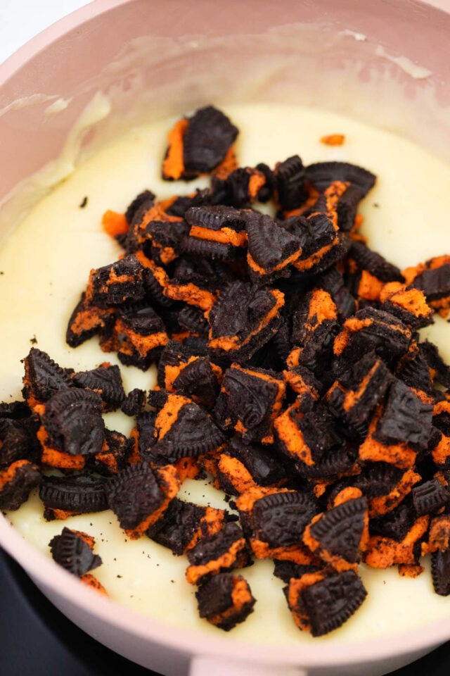 Stirring chopped Orange Oreos in melted white chocolate.